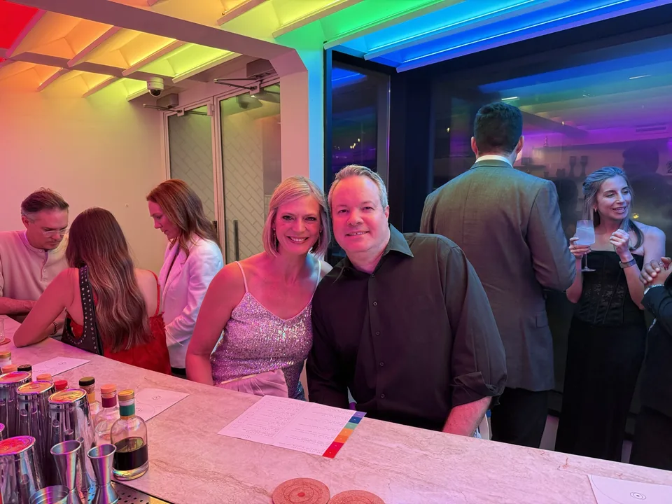 Mark and Jen at the rainbow-lit bar inside In Plain Sight