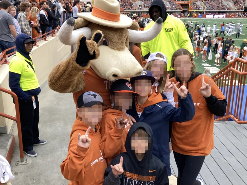 Children posing with Bevo at Darrell K Royal–Texas Memorial Stadium; the children’s faces are obscured for privacy