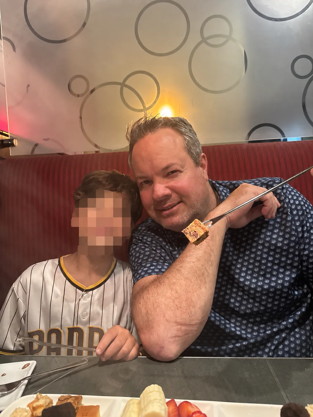 Mark and his son sharing dessert at The Melting Pot Austin; the child’s face is obscured for privacy