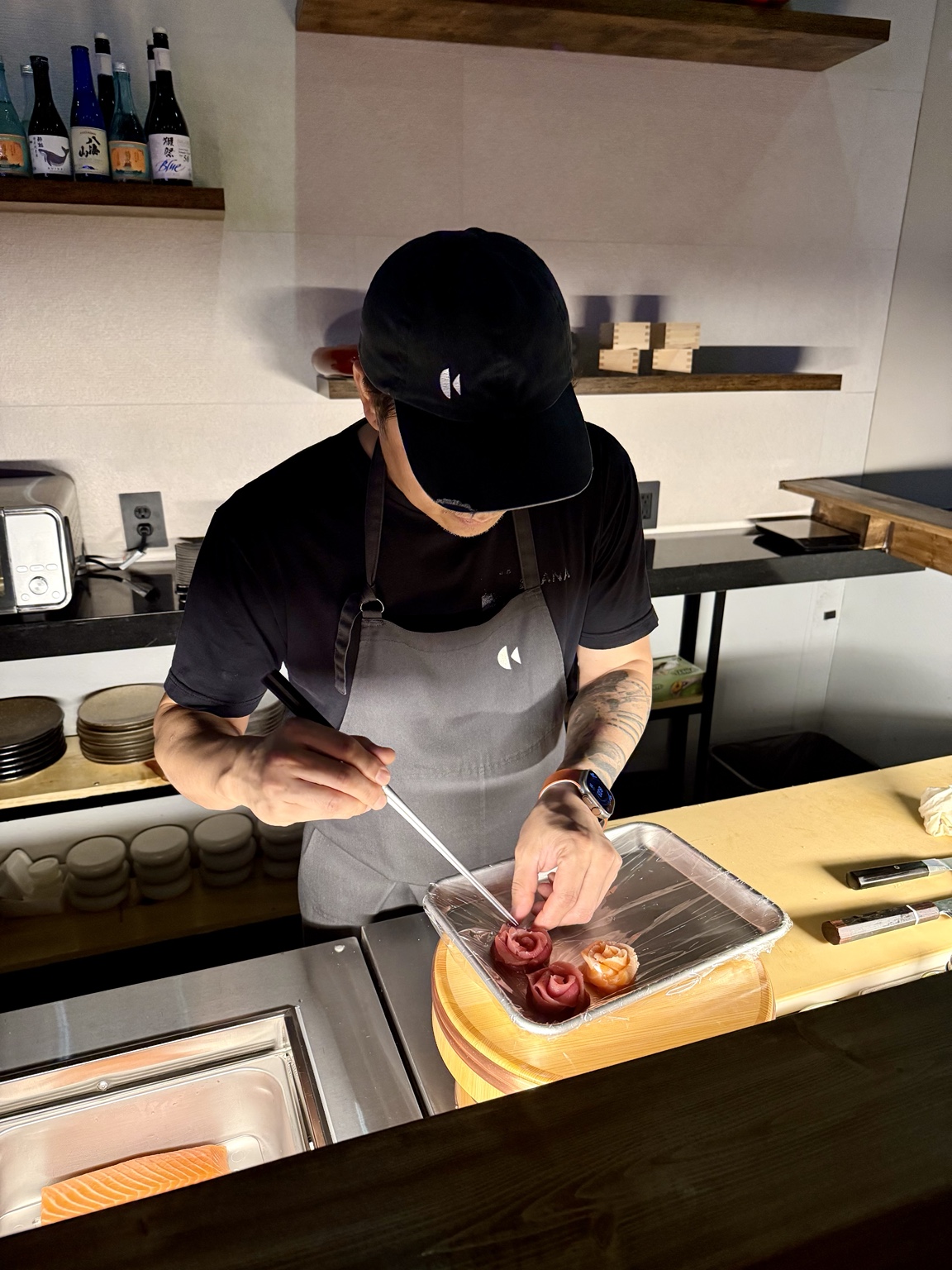 Chef creating rose-shaped sushi art at SOSU Izakaya