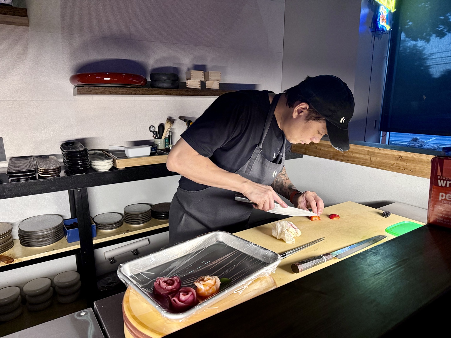 Chef preparing sushi behind the bar at SOSU Izakaya in Austin